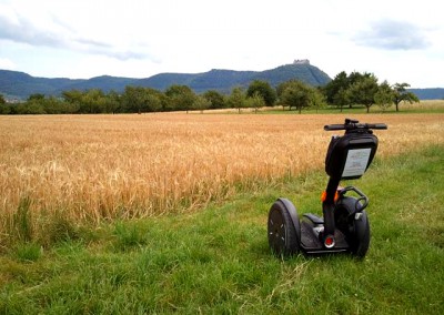 SEGWAY vor Felder und Streuobstwiesen mit Hohenneuffen im Hintergrund